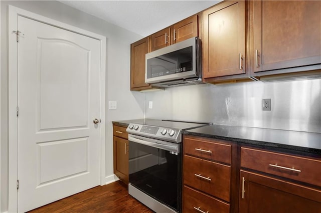 kitchen featuring stainless steel appliances and dark hardwood / wood-style floors