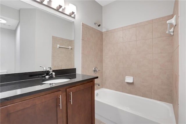 bathroom with tiled shower / bath and vanity