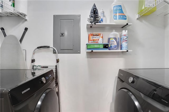 clothes washing area with washing machine and clothes dryer and electric panel