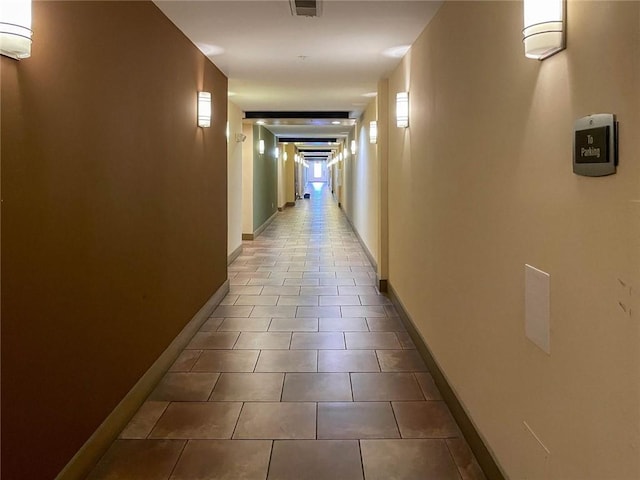 corridor featuring tile patterned floors and a wall unit AC