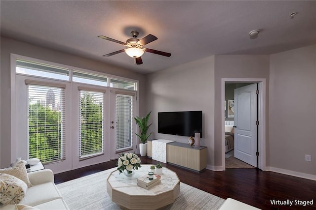 living room featuring ceiling fan and dark hardwood / wood-style flooring