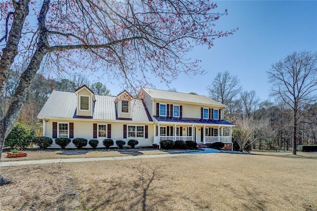 view of front of property with metal roof, a porch, and a front yard