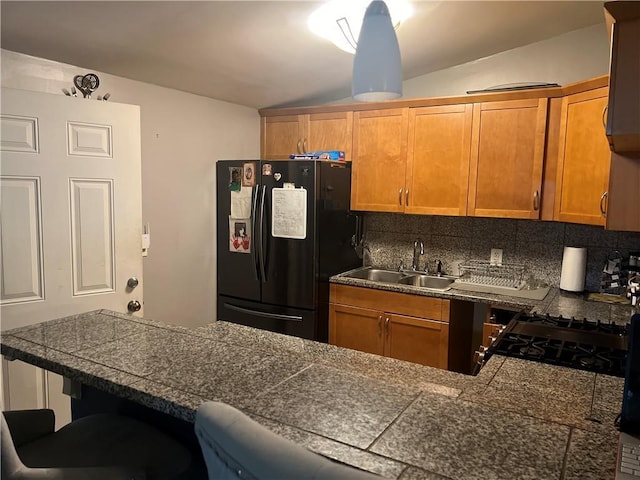 1506 Ravenel Rd, Conley, GA 30288 - kitchen with black refrigerator with ice dispenser, tile counters, a sink, a breakfast bar area, and tasteful backsplash