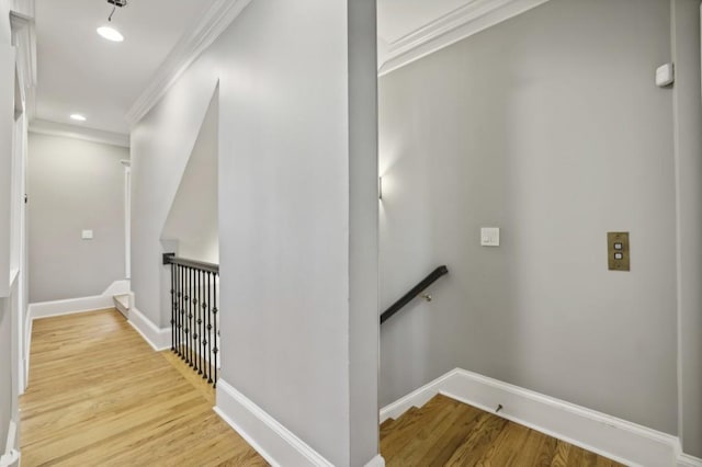 stairs featuring crown molding and wood-type flooring