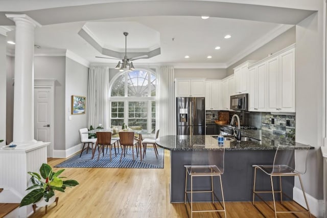 kitchen with stainless steel fridge with ice dispenser, sink, kitchen peninsula, and white cabinets