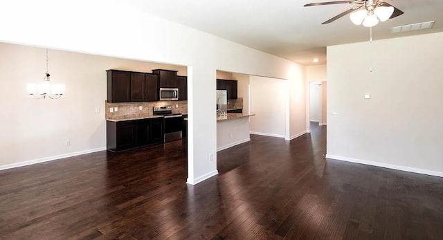 unfurnished living room featuring dark hardwood / wood-style flooring and ceiling fan with notable chandelier