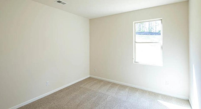 unfurnished room featuring light carpet