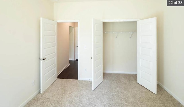 unfurnished bedroom with light carpet and a closet