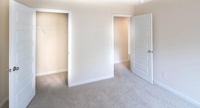 unfurnished bedroom featuring light colored carpet and a closet