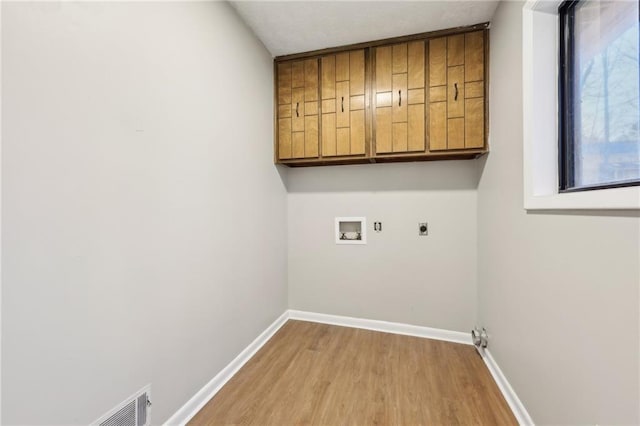 clothes washing area with washer hookup, light hardwood / wood-style floors, cabinets, and hookup for an electric dryer