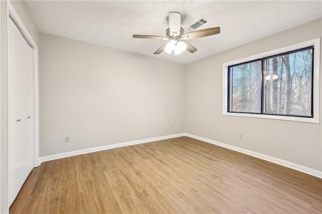 unfurnished bedroom featuring hardwood / wood-style flooring, a closet, and ceiling fan