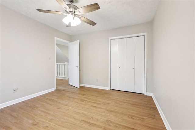 unfurnished bedroom featuring light wood-type flooring, ceiling fan, and a closet