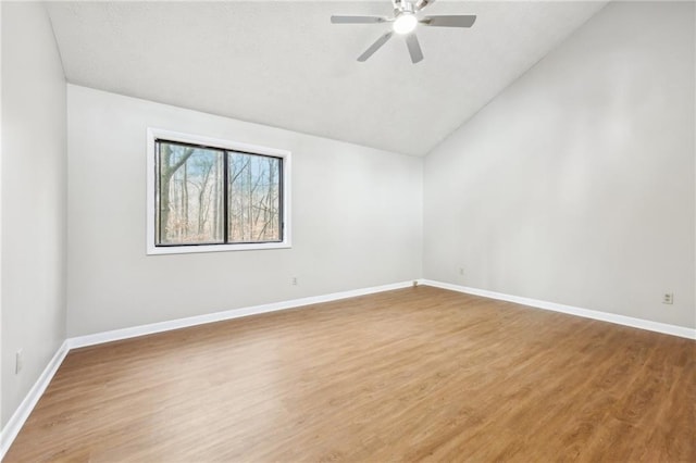 empty room featuring vaulted ceiling, ceiling fan, and hardwood / wood-style floors