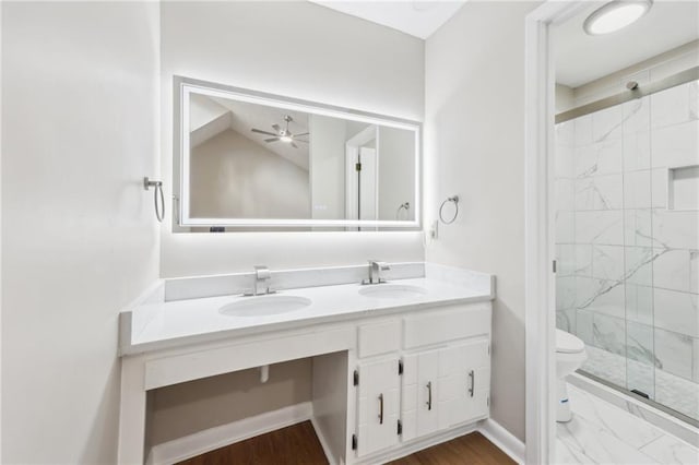 bathroom featuring lofted ceiling, a shower with door, ceiling fan, vanity, and toilet