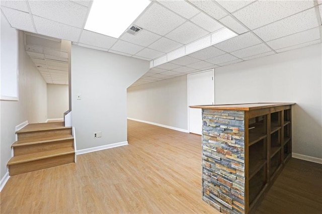 basement featuring hardwood / wood-style flooring and a paneled ceiling