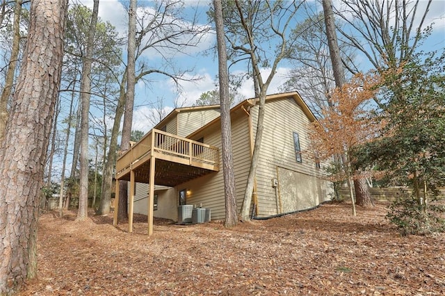 rear view of property with central AC unit and a deck