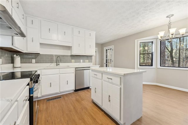 kitchen with white cabinetry, stainless steel appliances, and hanging light fixtures