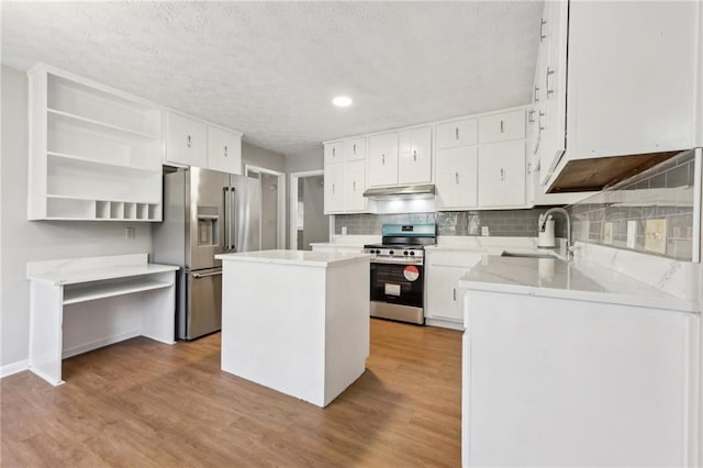 kitchen featuring a kitchen island, sink, white cabinets, stainless steel appliances, and light wood-type flooring