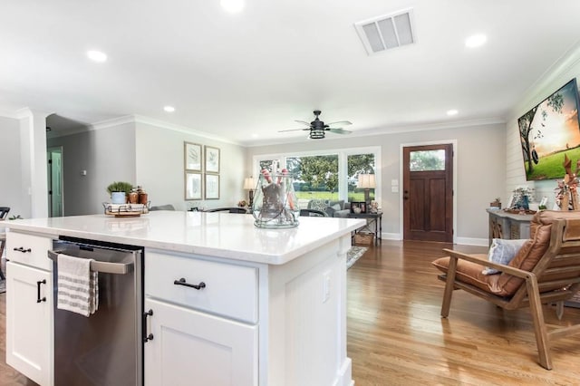 kitchen featuring stainless steel dishwasher, crown molding, white cabinetry, recessed lighting, and a kitchen island