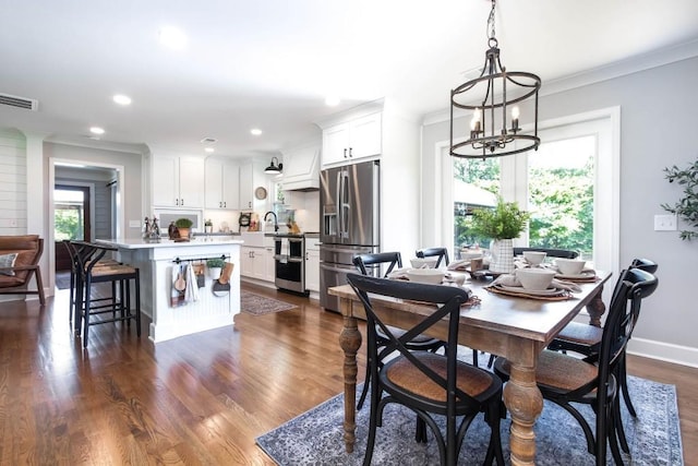 dining room featuring a chandelier, crown molding, recessed lighting, dark wood-style floors, and baseboards