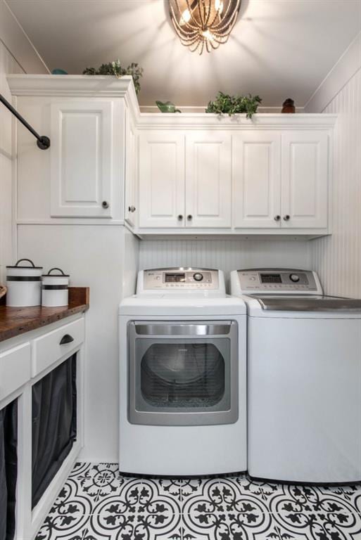 laundry room featuring washer and dryer, cabinet space, and light tile patterned flooring
