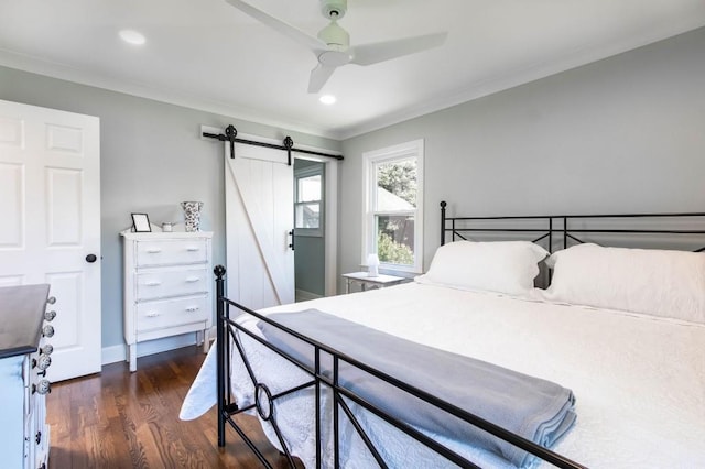 bedroom featuring a barn door, ornamental molding, dark wood finished floors, recessed lighting, and a ceiling fan