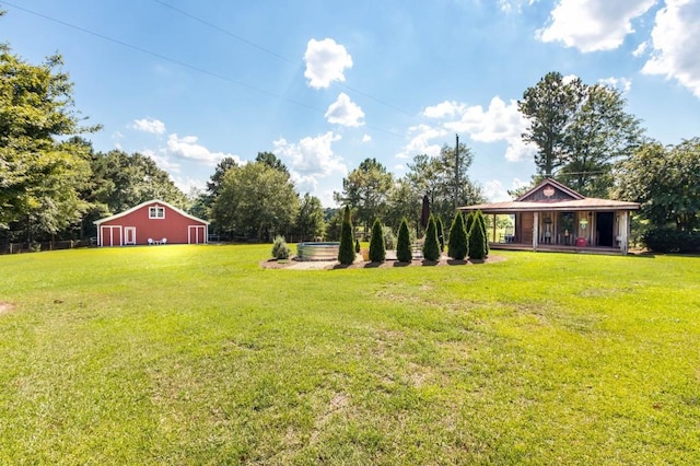 view of green lawn featuring an outdoor structure, covered porch, a pole building, and a garage