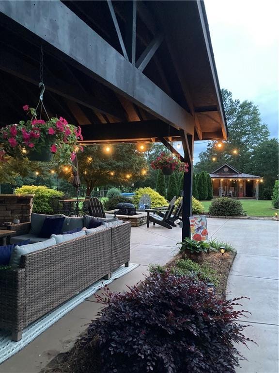 view of patio with an outdoor living space with a fire pit