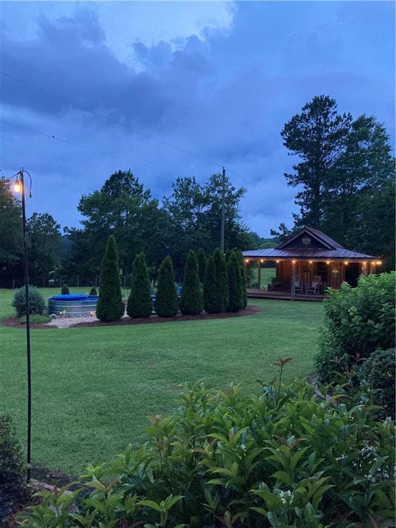 view of green lawn with covered porch