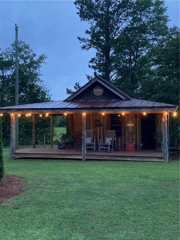 rear view of house featuring a yard and covered porch
