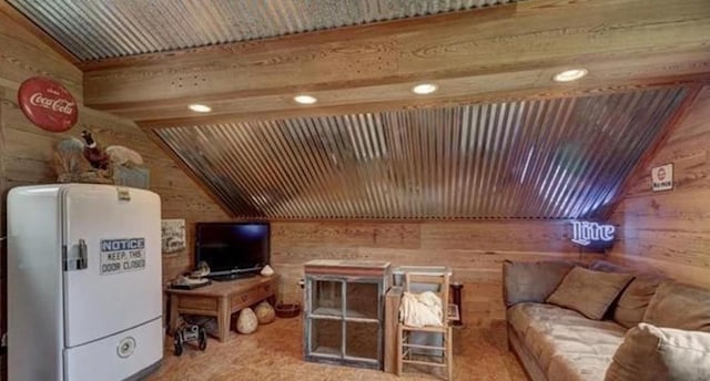 living area featuring vaulted ceiling, recessed lighting, and wooden walls