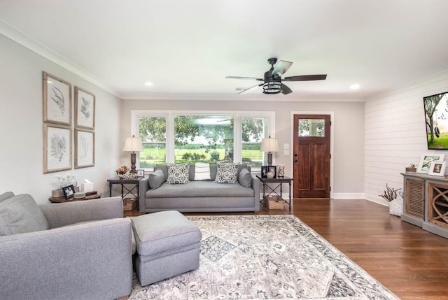 living room featuring healthy amount of natural light, crown molding, wood finished floors, ceiling fan, and baseboards