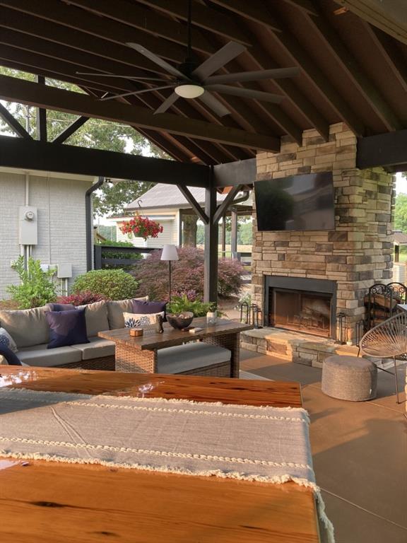 view of patio with an outdoor living space with a fireplace, a gazebo, and a ceiling fan
