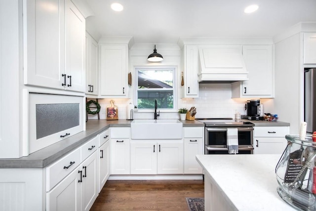 kitchen featuring appliances with stainless steel finishes, a sink, premium range hood, recessed lighting, and white cabinetry
