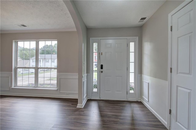 4975 Rockstone Way, Acworth, GA 30101 - foyer entrance with a textured ceiling, arched walkways, dark wood finished floors, wainscoting, and a decorative wall