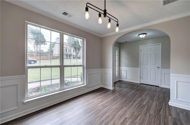 4975 Rockstone Way, Acworth, GA 30101 - empty room featuring arched walkways, a textured ceiling, dark wood-type flooring, a wainscoted wall, and ornamental molding