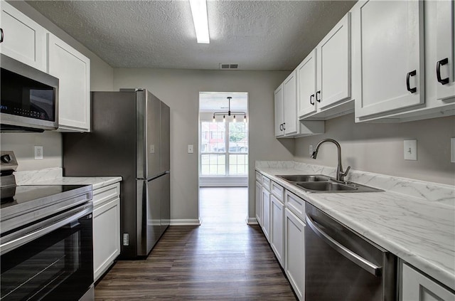 4975 Rockstone Way, Acworth, GA 30101 - kitchen with stainless steel appliances, a textured ceiling, dark wood-type flooring, white cabinetry, and light stone counters