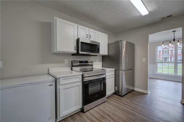 4975 Rockstone Way, Acworth, GA 30101 - kitchen featuring appliances with stainless steel finishes, wood finished floors, white cabinetry, a textured ceiling, and light countertops