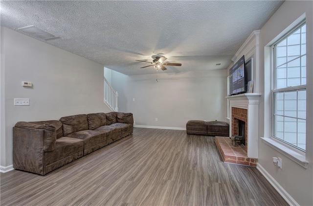 4975 Rockstone Way, Acworth, GA 30101 - living area with wood finished floors, ceiling fan, a textured ceiling, a brick fireplace, and stairway