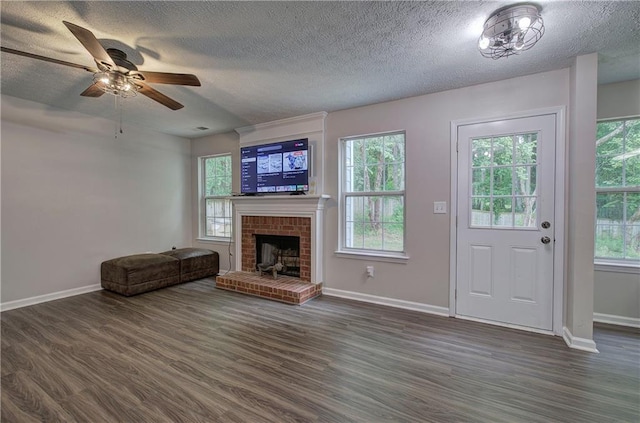 4975 Rockstone Way, Acworth, GA 30101 - unfurnished living room featuring a textured ceiling, dark wood finished floors, plenty of natural light, and a brick fireplace