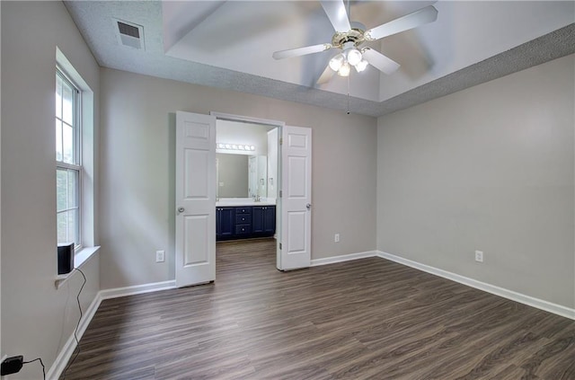 4975 Rockstone Way, Acworth, GA 30101 - unfurnished bedroom with dark wood finished floors, a raised ceiling, a ceiling fan, and connected bathroom