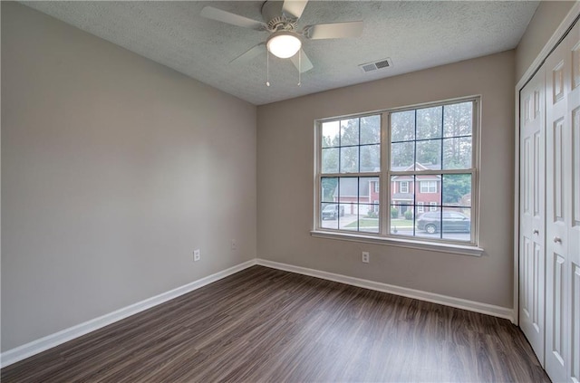 4975 Rockstone Way, Acworth, GA 30101 - unfurnished bedroom featuring a closet, dark wood-style flooring, a textured ceiling, and ceiling fan