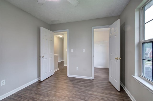 4975 Rockstone Way, Acworth, GA 30101 - unfurnished bedroom featuring dark wood-type flooring, multiple windows, and a walk in closet