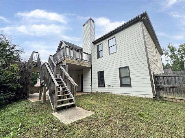 back of property with a wooden deck and a yard