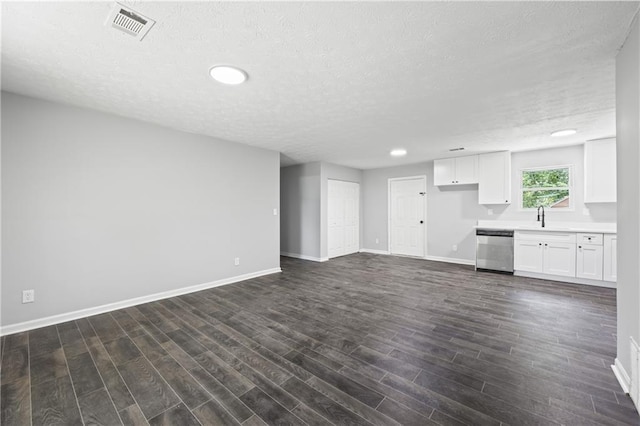 unfurnished living room with dark hardwood / wood-style flooring, sink, and a textured ceiling