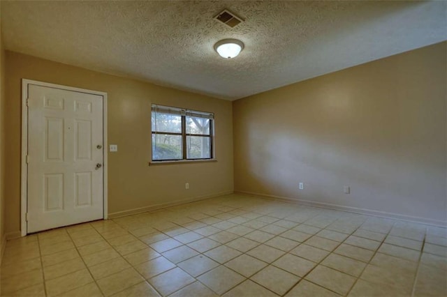 empty room featuring visible vents, a textured ceiling, baseboards, and light tile patterned floors