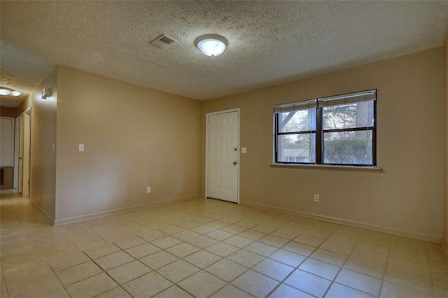 spare room with visible vents, baseboards, and light tile patterned floors