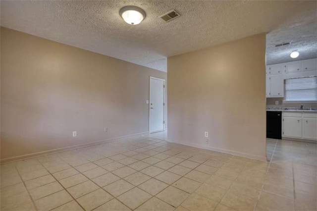 unfurnished room featuring visible vents, a textured ceiling, baseboards, and light tile patterned floors