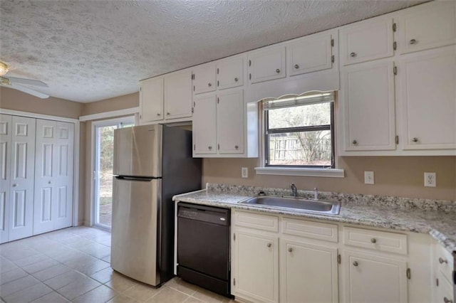 kitchen featuring a sink, white cabinets, dishwasher, and freestanding refrigerator