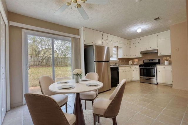 kitchen featuring under cabinet range hood, visible vents, white cabinetry, light countertops, and appliances with stainless steel finishes